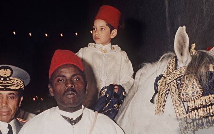 Le prince héritier Sidi Mohammed sur un cheval, se dirigeant vers le Mausolée Moulay Driss à Fès au mois de mars 1971 à l'occasion de sa circoncision, conformément aux traditions ancestrales des Alaouites © DR
