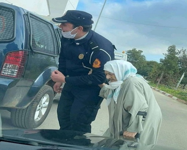 Un policier assistant une vieille dame en chemin vers le centre de vaccination anti-Covid-19 © DR